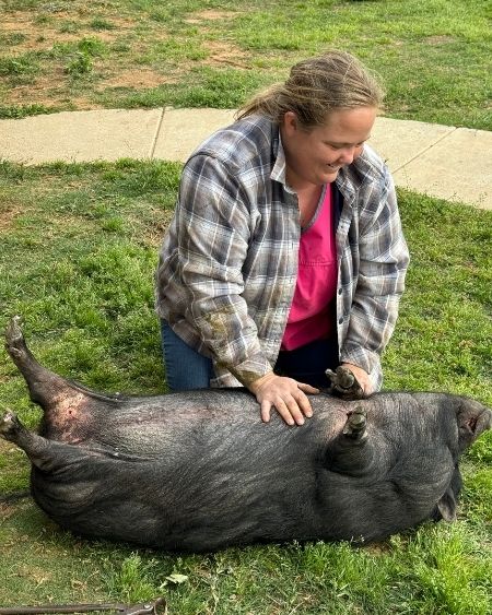 Texas West Animal Health Staff petting a pig