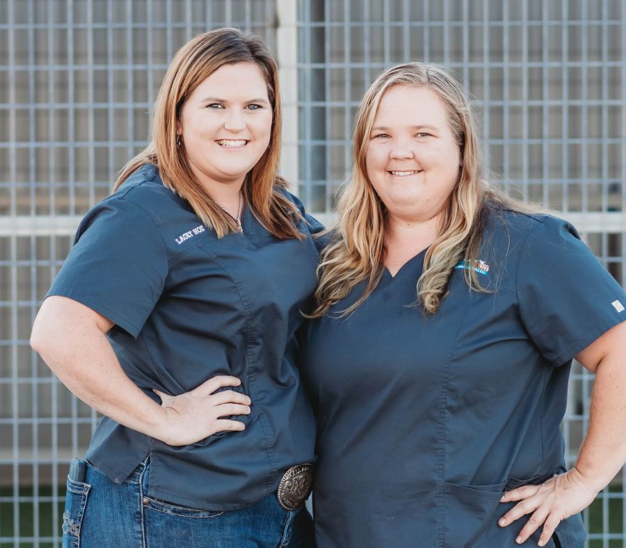 Two women in blue medical scrubs stand outdoors with hands on hips, Two women in blue medical scrubs stand outdoors with hands on hips,